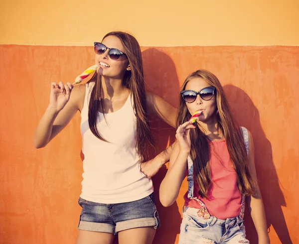 Duas meninas com sorvete na parede de fundo — Fotografia de Stock