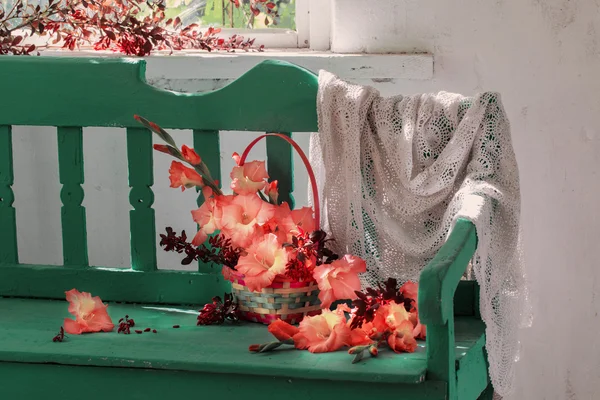 Flowers in basket  on bench indoor — Stock Photo, Image
