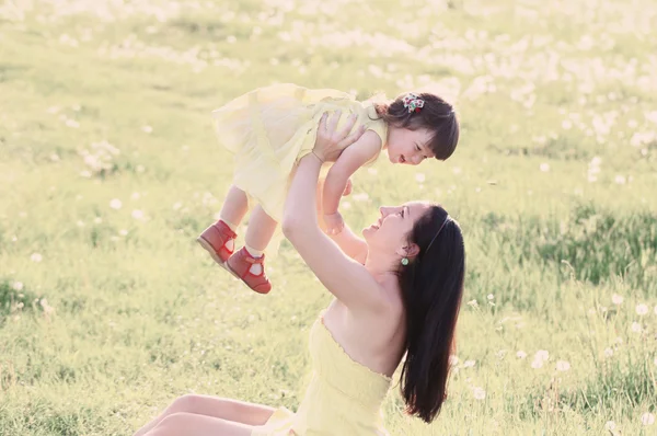 Moeder en dochter op achtergrond gras — Stockfoto