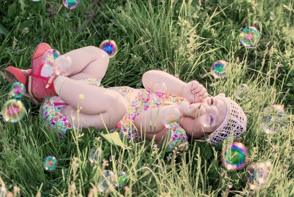 Счастливый ребенок с мыльными пузырями на открытом воздухе — стоковое фото