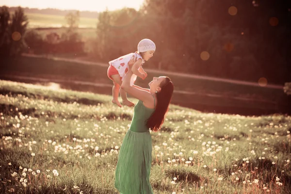 Gelukkig moeder bedrijf baby buiten — Stockfoto