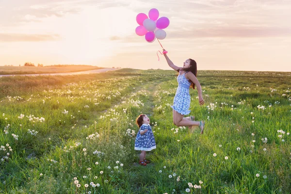 Bebê e mãe com balões ao ar livre — Fotografia de Stock