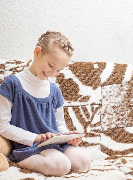 Menina bonita com tablet pc em casa — Fotografia de Stock