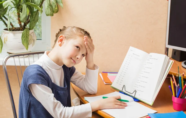 Müde Schülerin mit Buch auf dem Schreibtisch — Stockfoto