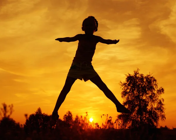 Menina pulando ao pôr do sol — Fotografia de Stock