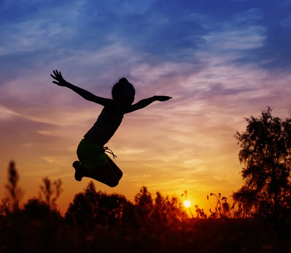 Kız günbatımında atlama