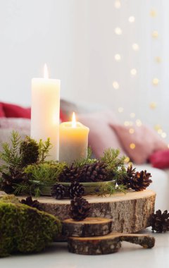 Beyaz masadaki mumların kompozisyonu evdeki kanepenin arka planına karşı