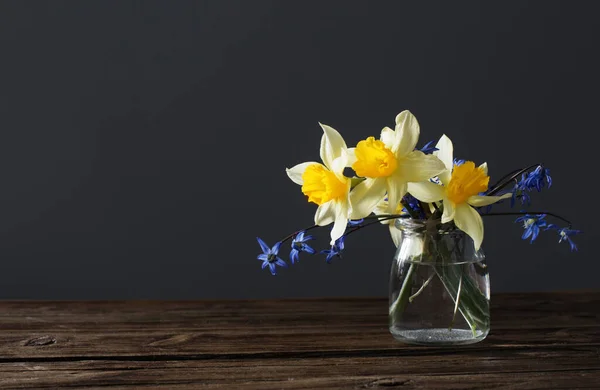 Gele Narcissen Blauwe Sneeuwklokjes Vaas Houten Tafel Donkere Achtergrond — Stockfoto