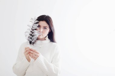 Beyaz arka planda beyaz eğreltiotu yaprağı olan güzel genç kız.