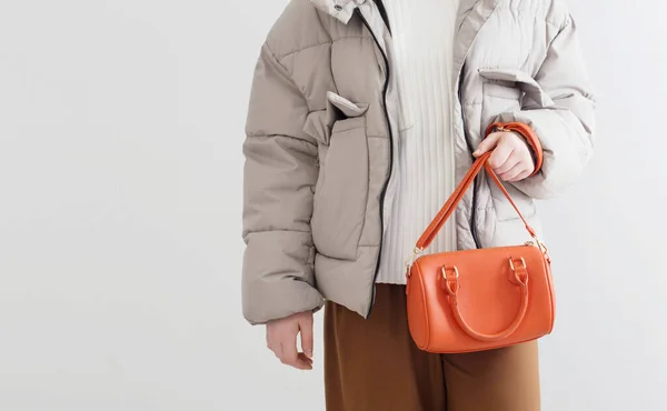 オレンジ色のハンドバッグを着た短いダウンジャケットの女性 — ストック写真