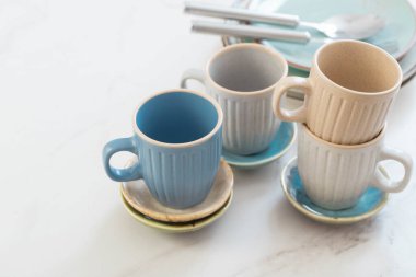 seramik bardaklar ve tabaklar beyaz mermer masa üzerinde