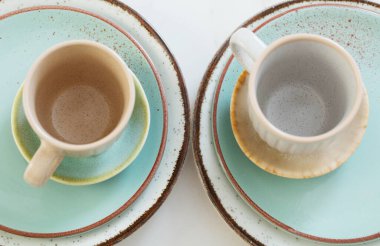 Beyaz mermer masada iki seramik bardak ve tabak.