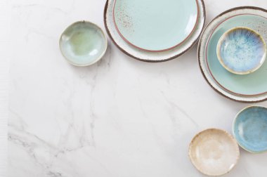 Beyaz mermer masada çeşitli seramik tabaklar