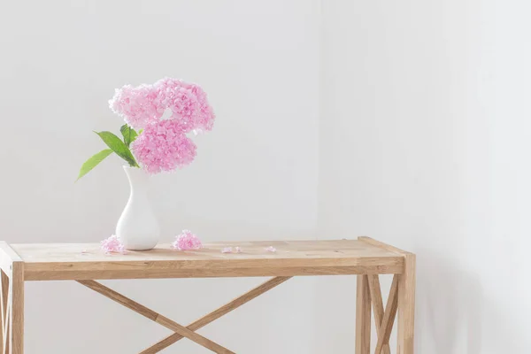 背景の白い壁に白い花瓶にピンクのアジサイ — ストック写真