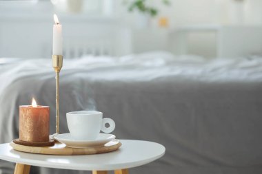 Beyaz kahve fincanı ve kapalı masa mumları.