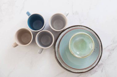 seramik bardaklar ve tabaklar beyaz mermer masa üzerinde