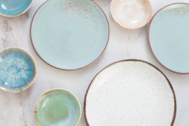 Beyaz mermer masada çeşitli seramik tabaklar