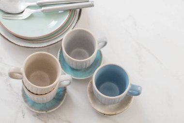 seramik bardaklar ve tabaklar beyaz mermer masa üzerinde