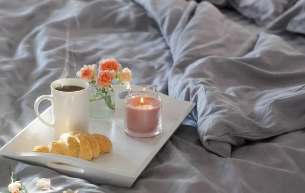 Φλιτζάνι Καφέ Κρουασάν Και Ροζ Τριαντάφυλλα Στο Κρεβάτι Στο Υπνοδωμάτιο — Φωτογραφία Αρχείου