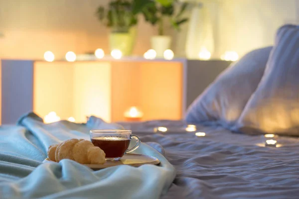 晚上在床上喝一杯放羊角面包的咖啡 — 图库照片