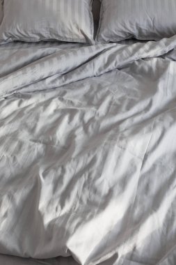 Gri çarşaflar gün ışığında Yatakta yatak odasında
