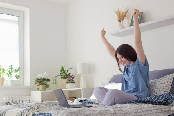 happy teen girl with laptopat home on bed 