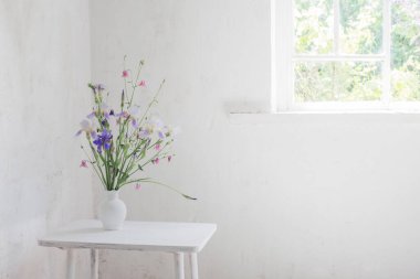 Beyaz vazodaki çiçekler beyaz mahsul iç kısımlarda