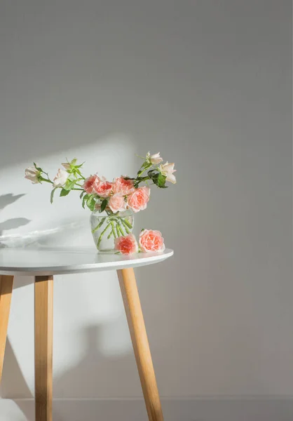 白色现代桌子上的玻璃瓶中的粉红玫瑰 背景白墙 — 图库照片