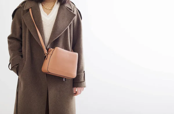 白い背景にハンドバッグを持つ秋のコートの若い女性 — ストック写真