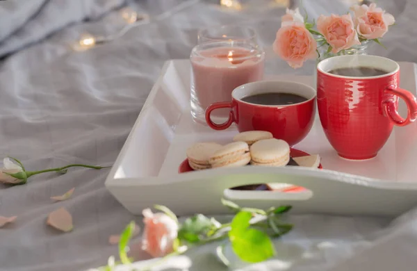 Δύο Κόκκινα Φλιτζάνια Καφέ Και Λουλούδια Στο Κρεβάτι — Φωτογραφία Αρχείου