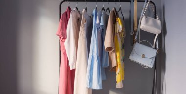 Açık renkli kadınlar yaz kıyafetleri ve askıda ayakkabılar.