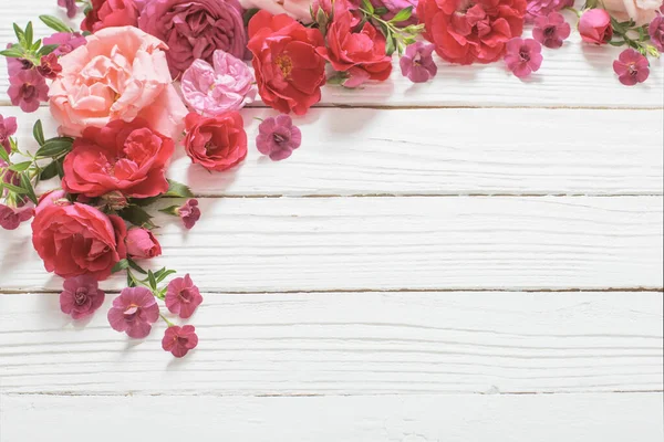 白い木の背景にピンクと赤のバラ — ストック写真