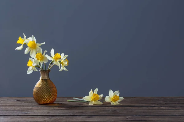 黑色背景的木制桌子上花瓶里的黄色水仙 — 图库照片