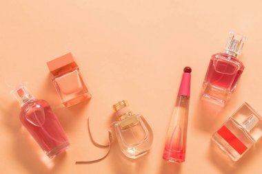 Turuncu arka planda bir grup parfüm şişesi