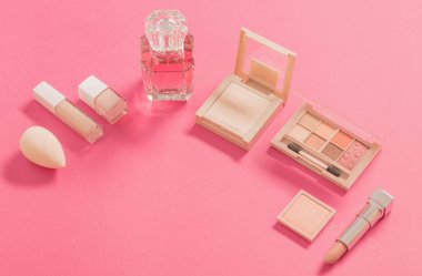 Pembe arka planda parfümlü dekoratif kozmetik.