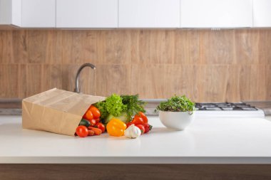 Mutfaktaki beyaz masada taze sebzeler.