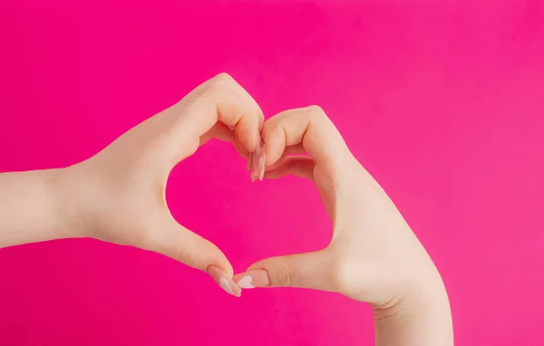 Mãos Femininas Fazendo Gesto Coração Fundo Rosa — Fotografia de Stock