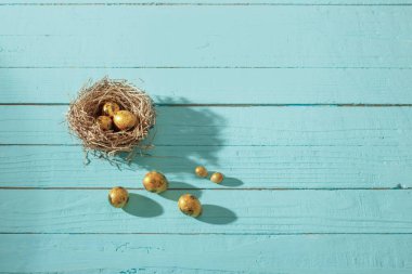 Eski mavi ahşap arka planda Paskalya altın yumurtaları