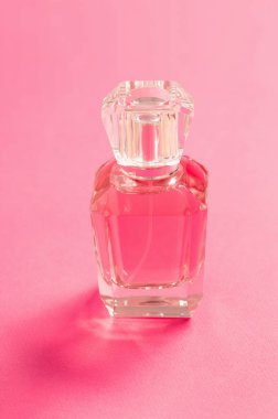 Pembe arka planda parfüm şişesi