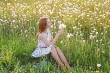 Karahindiba tarlasında genç ve güzel bir kadın.