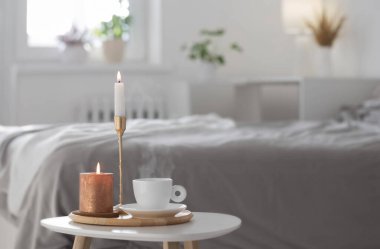 Beyaz kahve fincanı ve kapalı masa mumları.