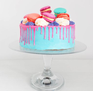 Beyaz arkaplanda pembe ve mavi dekoru olan bir parça kek.