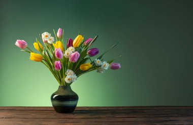 Tahta masadaki seramik vazoda bahar çiçekleri