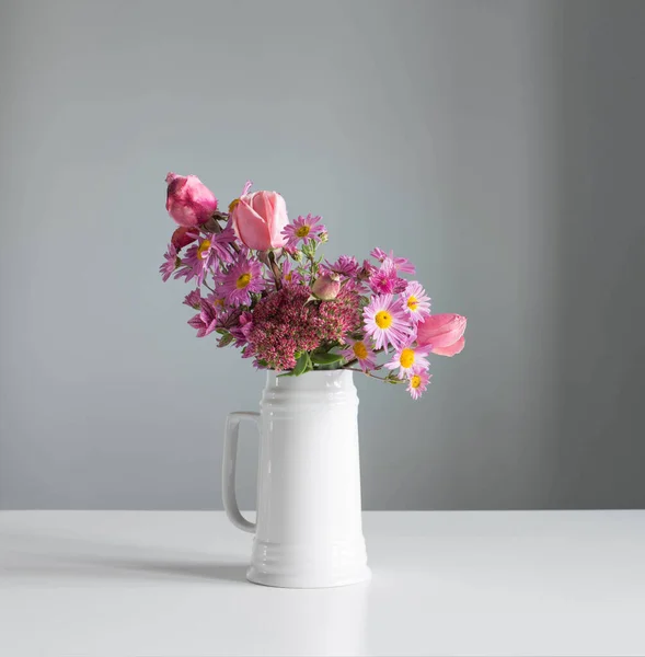 Рожеві Квіти Білому Глечику Фоні Сірої Стіни — стокове фото