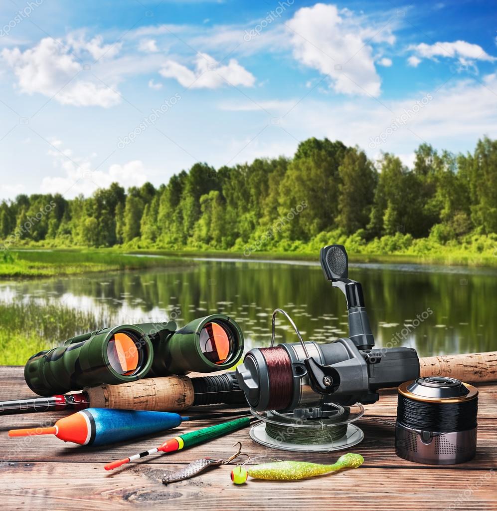 Fishing tackle on a pontoon on the background of the lake ⬇ Stock Photo