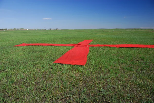 Red cross on the grass — Stock Photo, Image