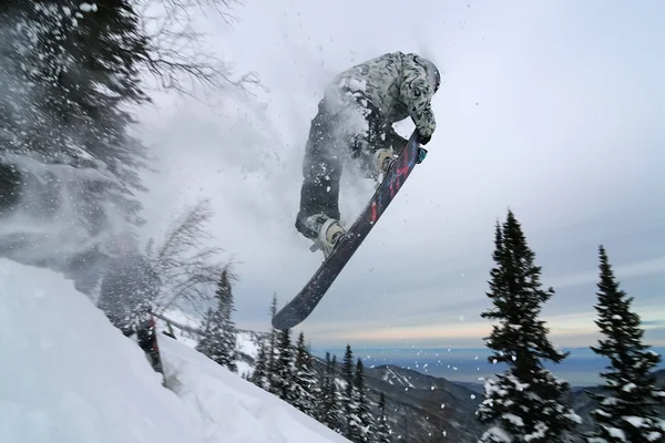 Snowboardzista skoki i robi nos chwycić — Zdjęcie stockowe