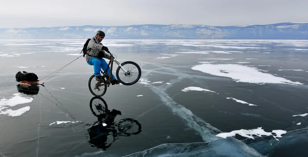 Bicycle tourist on the frozen lake — Stock Photo, Image