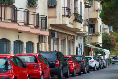 Scilla şehrinin merkez caddesinde araba parkı ve zarif binalar var. İtalyan tatili, Calabria bölgesi.