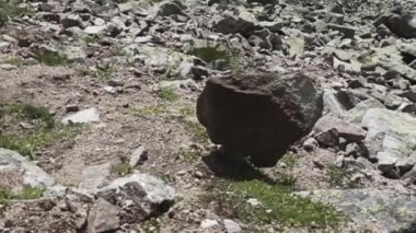 Bir kayanın yamaçtan düşmesi bir kayanın düşmesine neden olur.